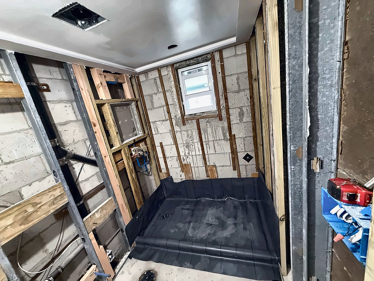 Rough-in stage with new PEX supply, a set valve and the black shower pan liner folded into the corners