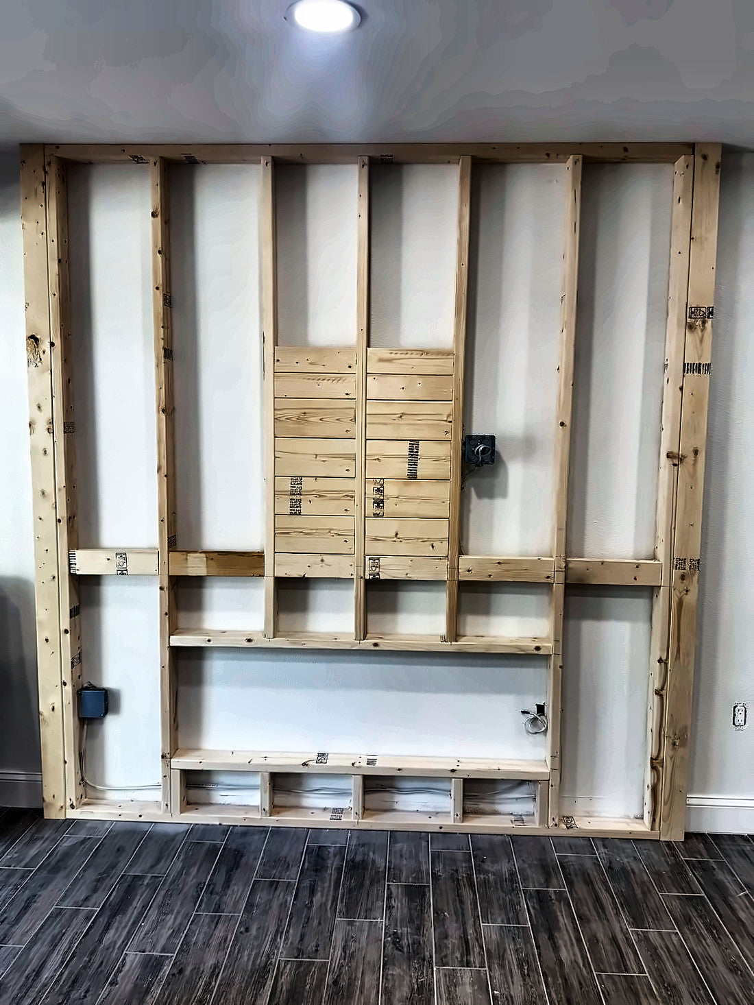 New stud wall framed out in front of the existing wall with a boxed fireplace opening